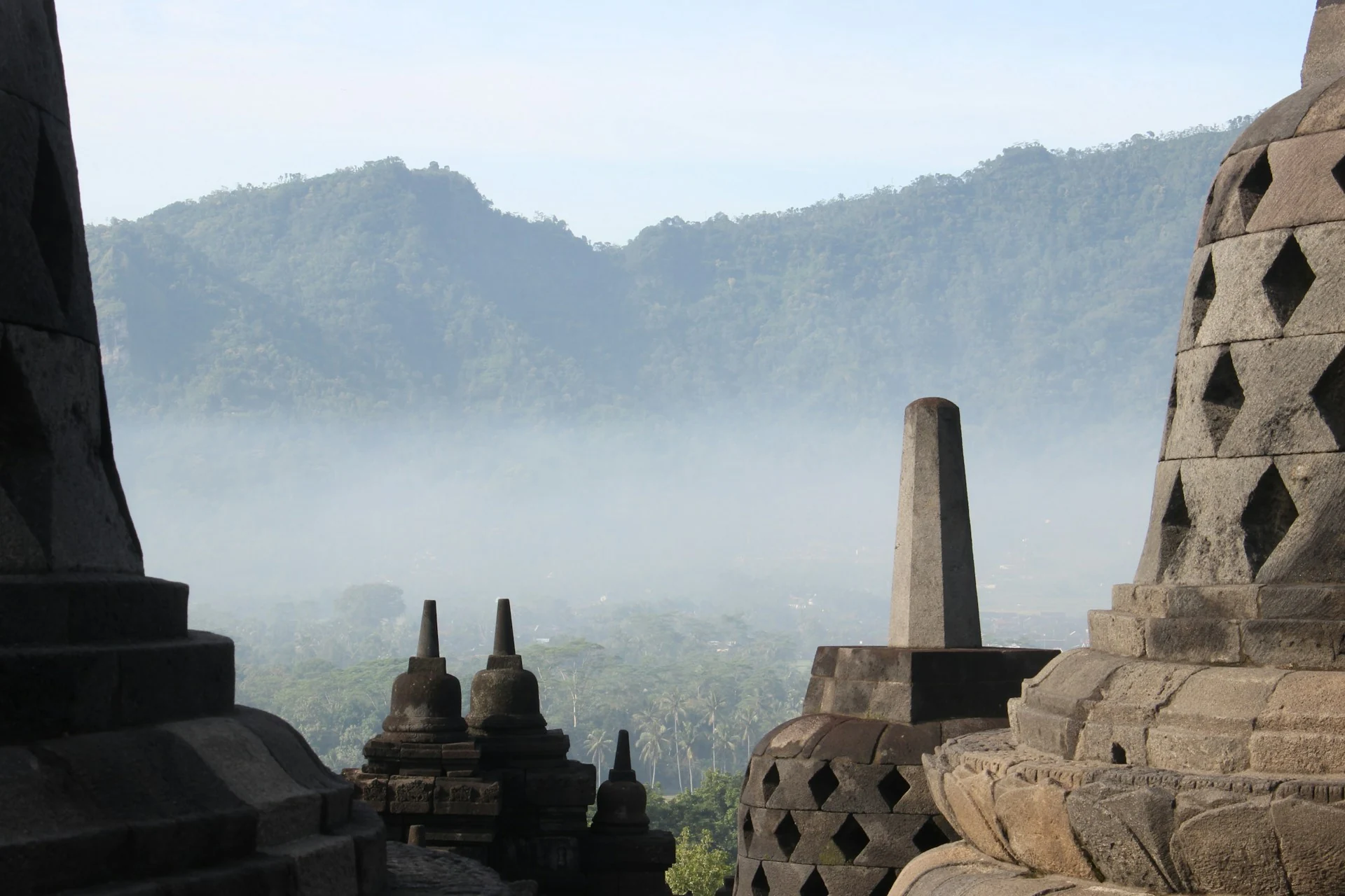 Stone stupas and misty hills viewed from Borobudur