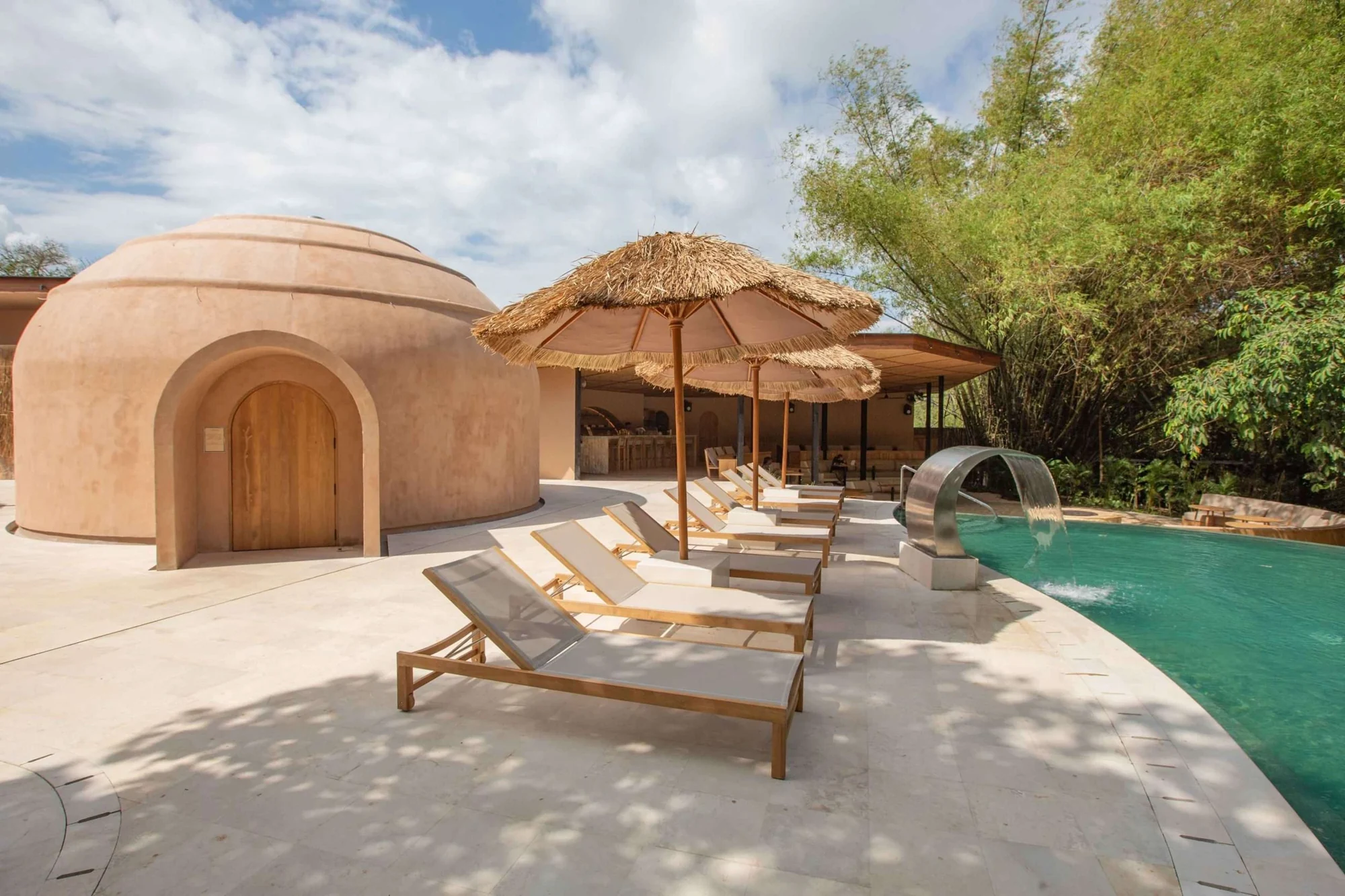 A quiet spa courtyard with a pool, loungers and parasols